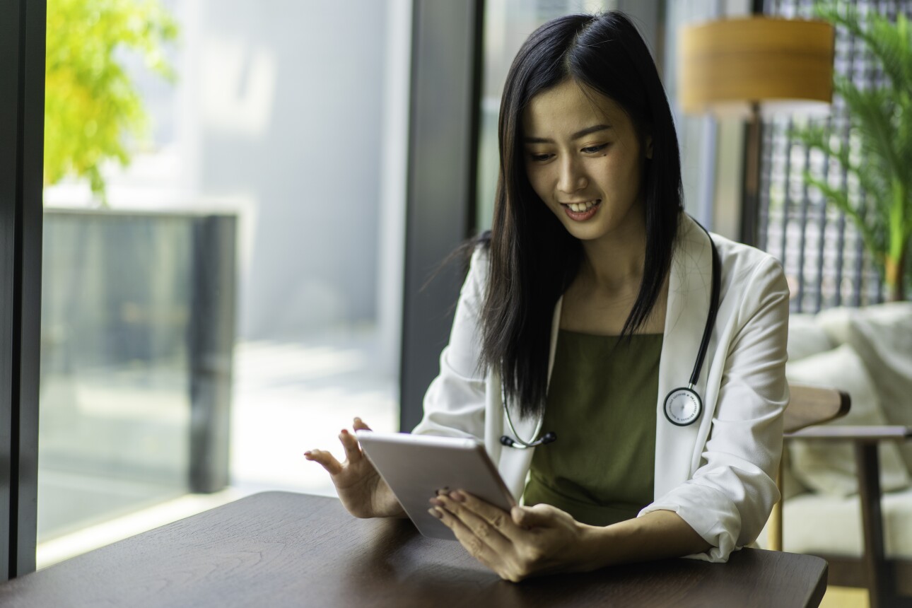 Asian Doctor Using Digital Tablet in her office