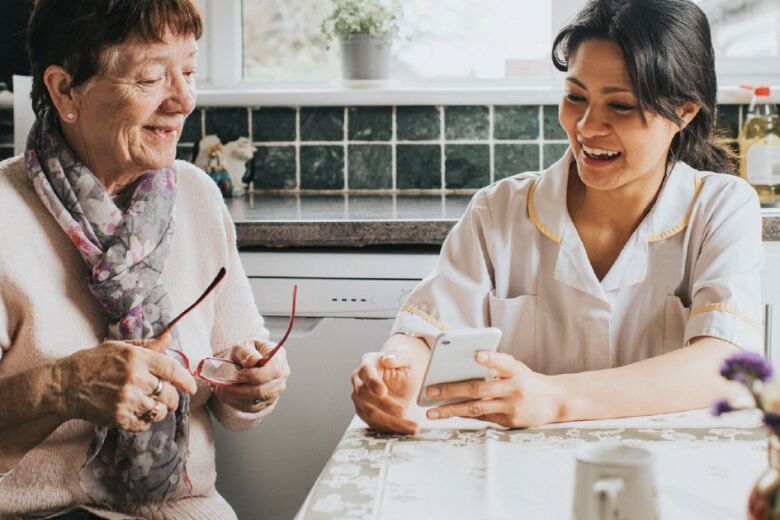 daughter helping senior mother with her smartphone