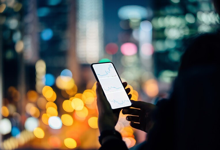 person looking at financial graphs on their phone