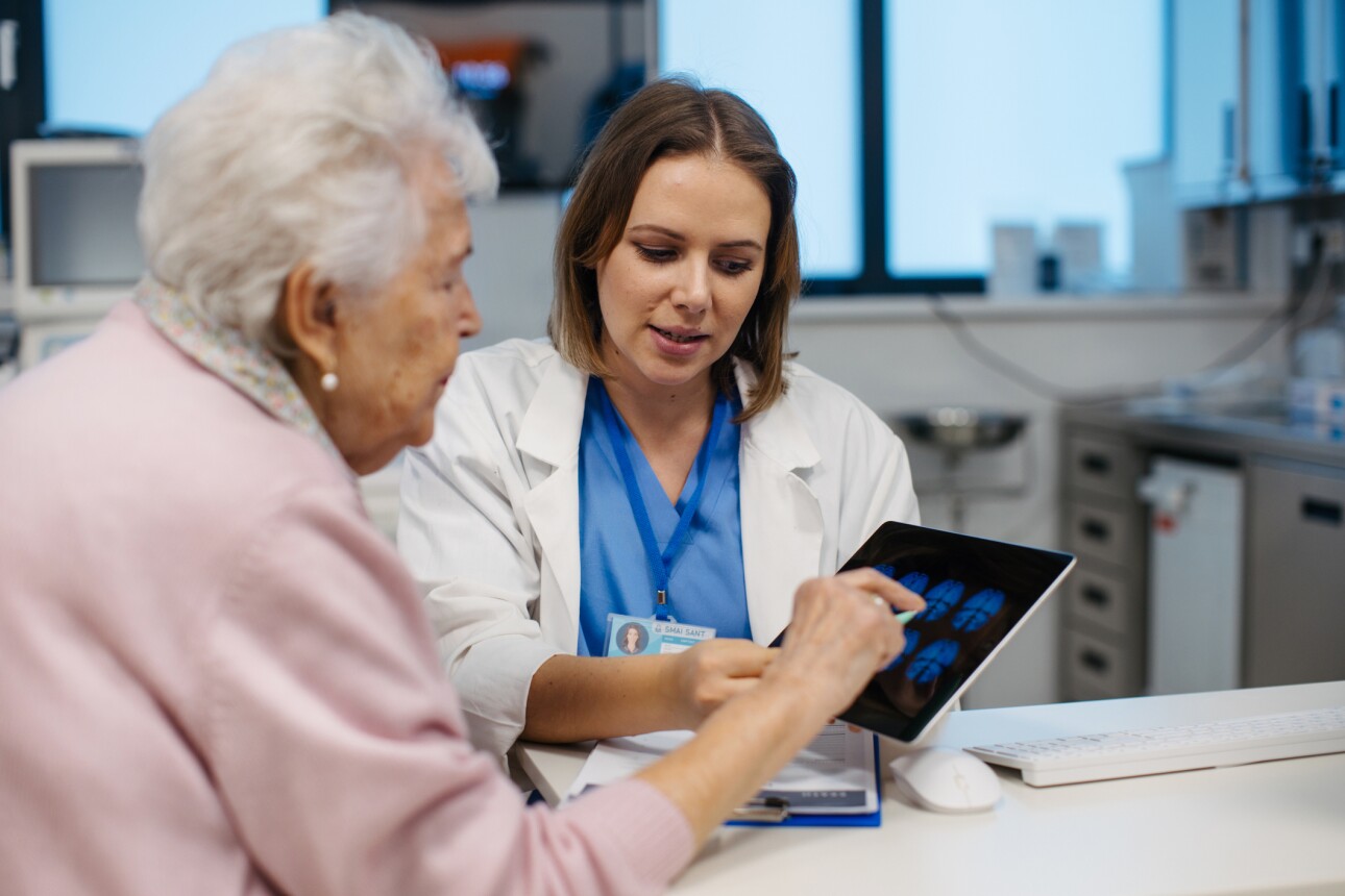 Doctor explaining results of MRI scan of brain to senior patient.