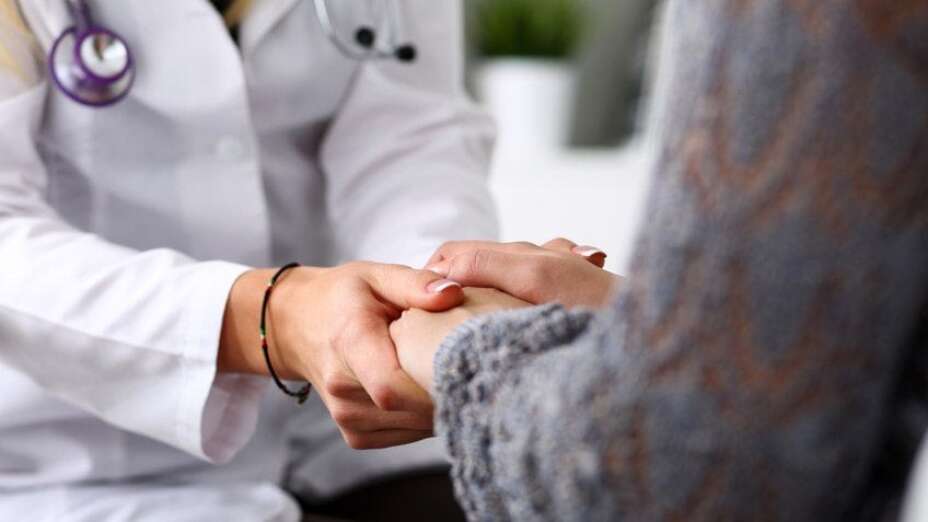 doctors hands holding the hands of a patient