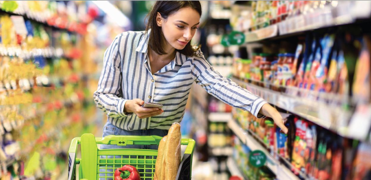 woman shopping in the aisle of a grocery store