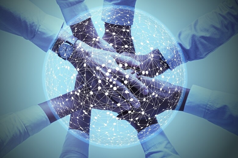 network of data points over a group people with their hands stacked one on top of the other