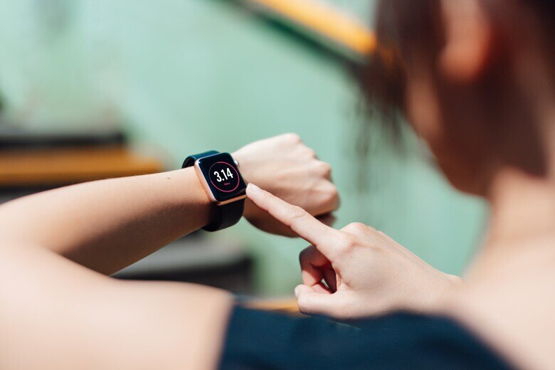 woman looking at her smart watch on her wrist