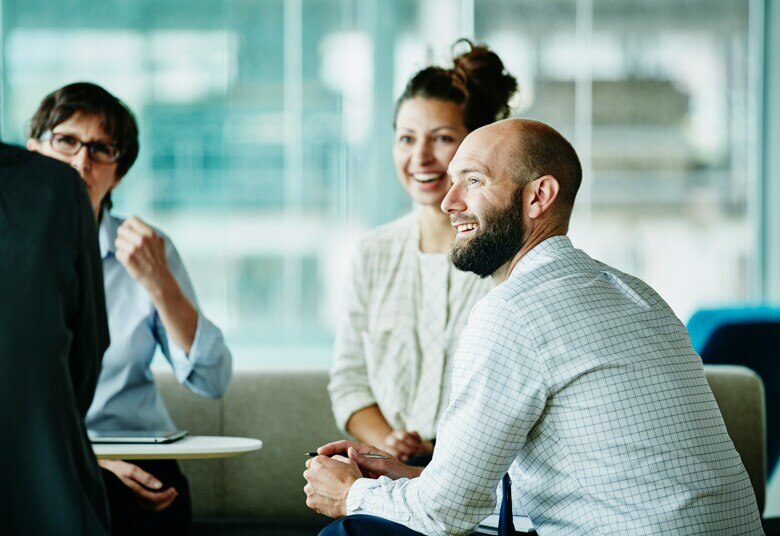 group of people sitting having a discussion and smiling