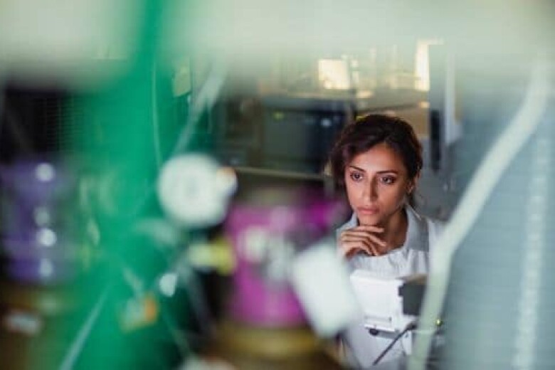 female lab worker with thoughtful expression