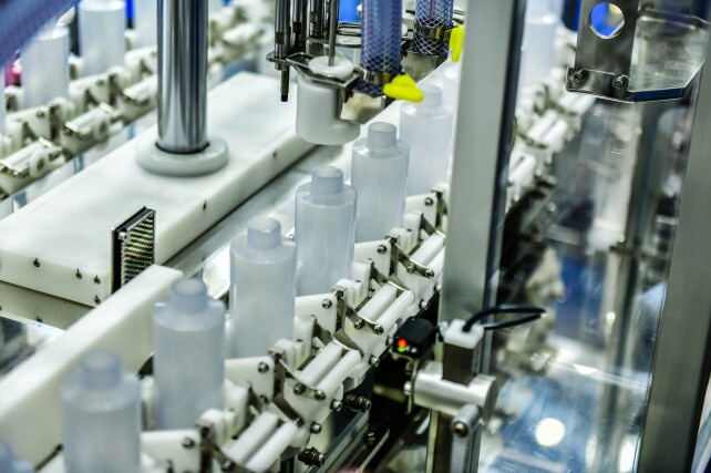 White plastic bottles in a conveyor belt. self care manufacturing