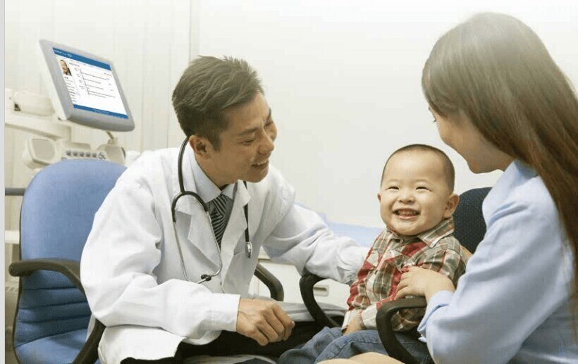 doctor visiting with young patient and his mother