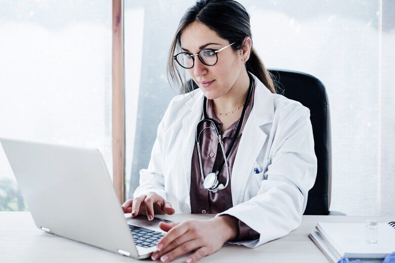 doctor reviewing patient information on her computer in her office