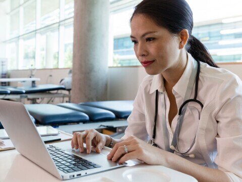 female doctor working on her laptop in therapy room