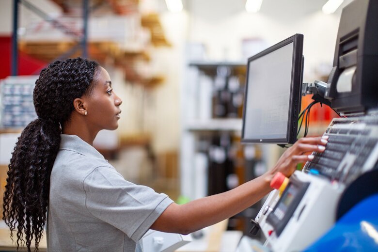 woman operating the computer in large warehouse