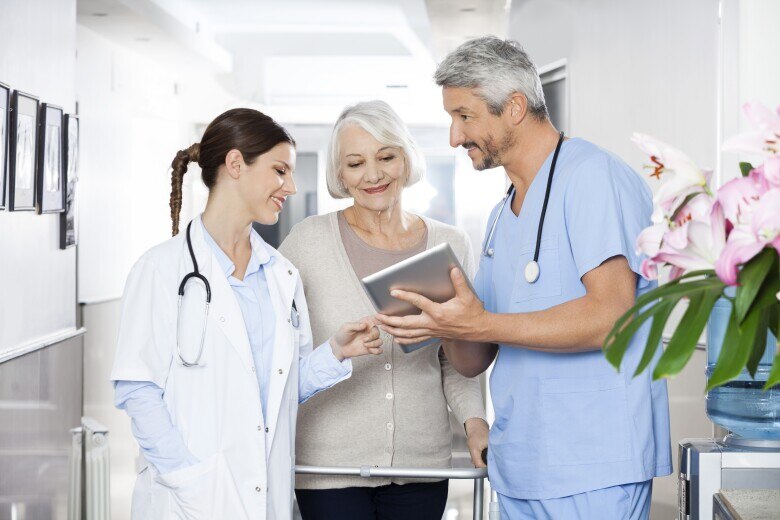 doctors reviewing information on a tablet with their patient