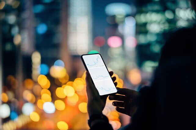 person looking at financial graphs on their phone