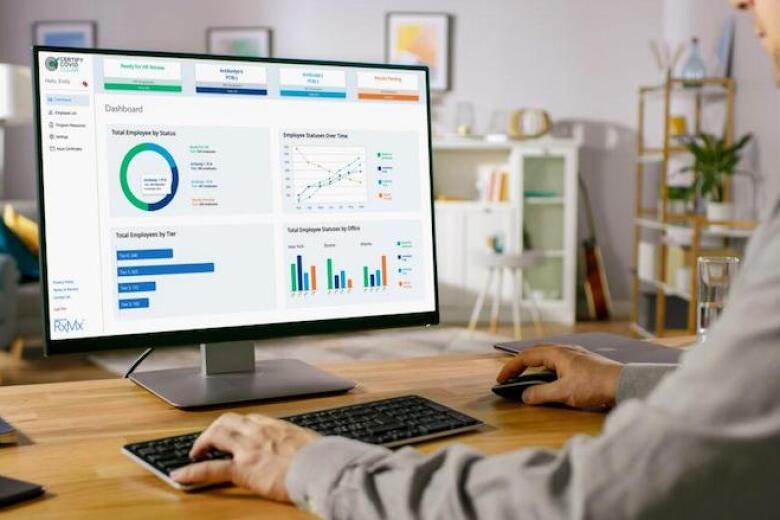 Man viewing various charts on computer monitor.