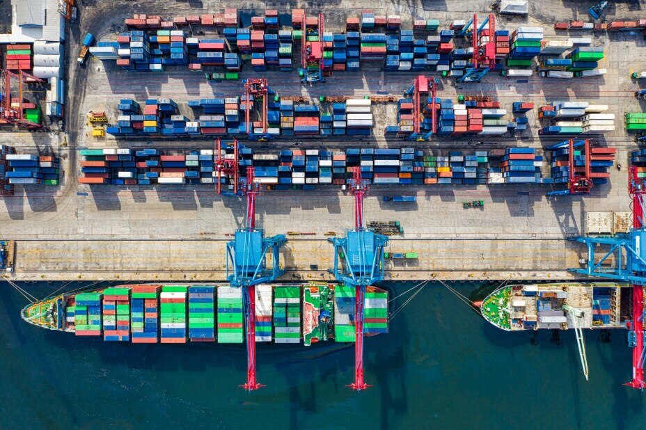 aerial view of a busy dock where container ships are being loaded and unloaded