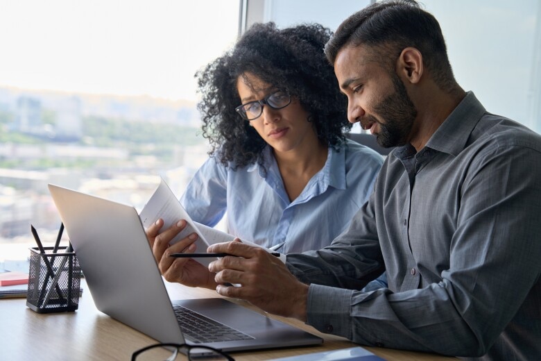 man and woman lookin at a laptop