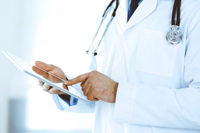 male doctor tapping something on a tablet