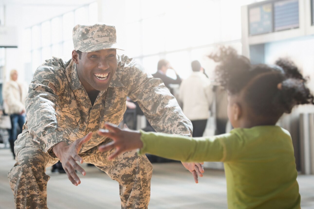 young daughter running into the arms of her veteran father