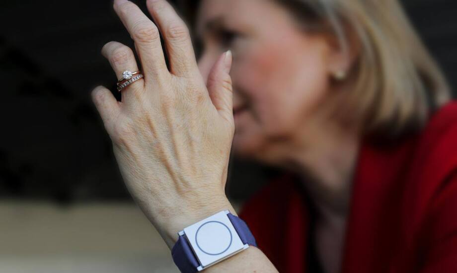 women's hand wearing wedding rings and a smart watch