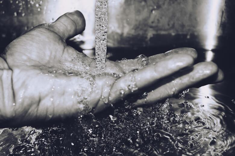 hand under flowing water from a faucet