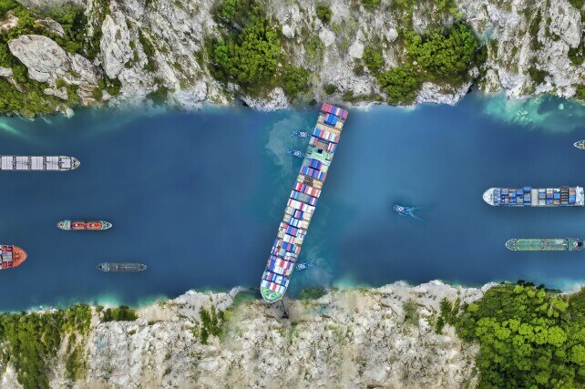 Aerial view/A large cargo ship swept through the waterways in the Suez Canal, making it impossible for other ships to go.