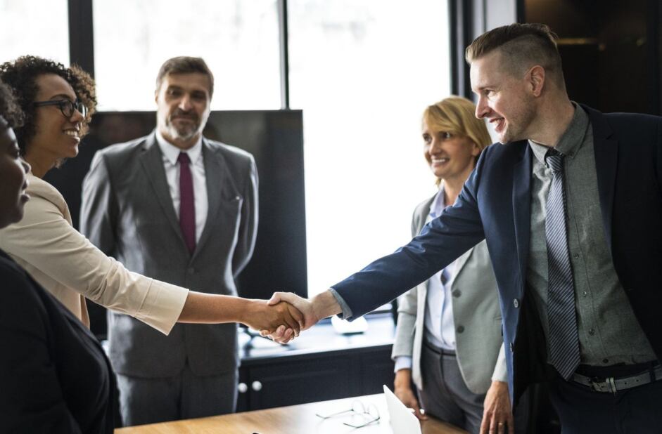 group of business leaders shaking hands upon meeting for a conference