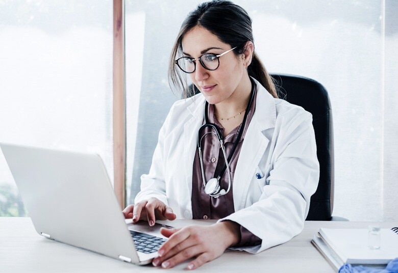 doctor reviewing patient information on her computer in her office
